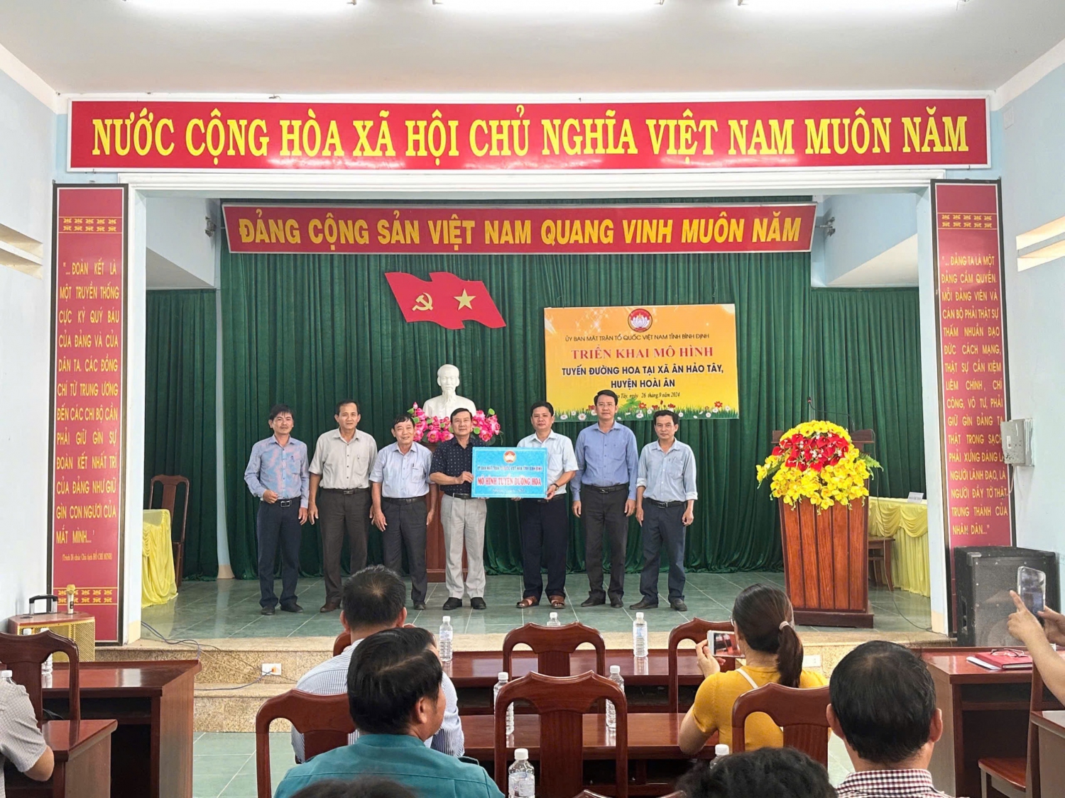 Ông Phạm Văn Nam - Tỉnh ủy viên, Phó Chủ tịch Thường trực Ủy ban MTTQ Việt Nam tỉnh trao bảng tượng trưng triển khai mô hình tuyến đường hoa tại xã Ân Hảo Tây, huyện Hoài Ân.